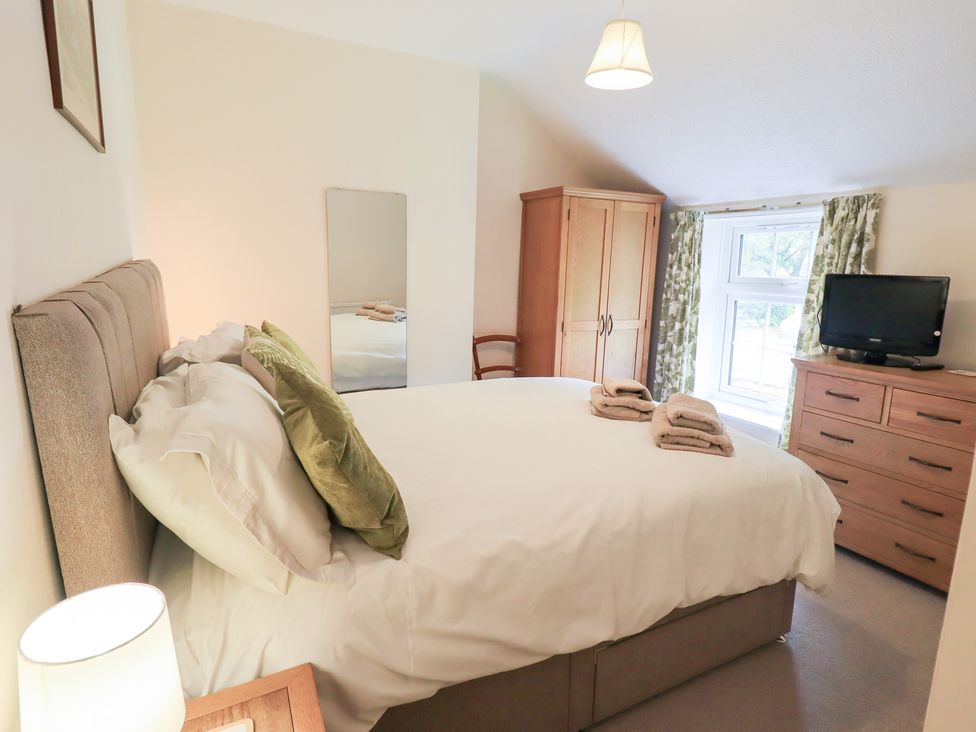 A bedroom with a bed and television at Millcroft in Glenridding