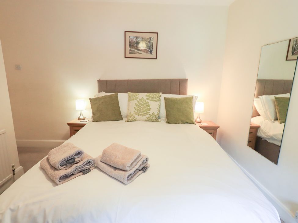 A bedroom with a bed and bedside table at Millcroft in Glenridding