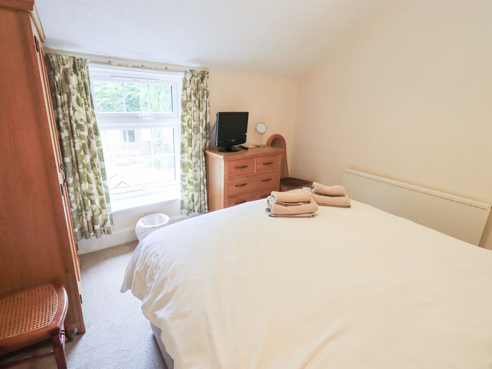 A bedroom with a bed and a television at Millcroft in Glenridding