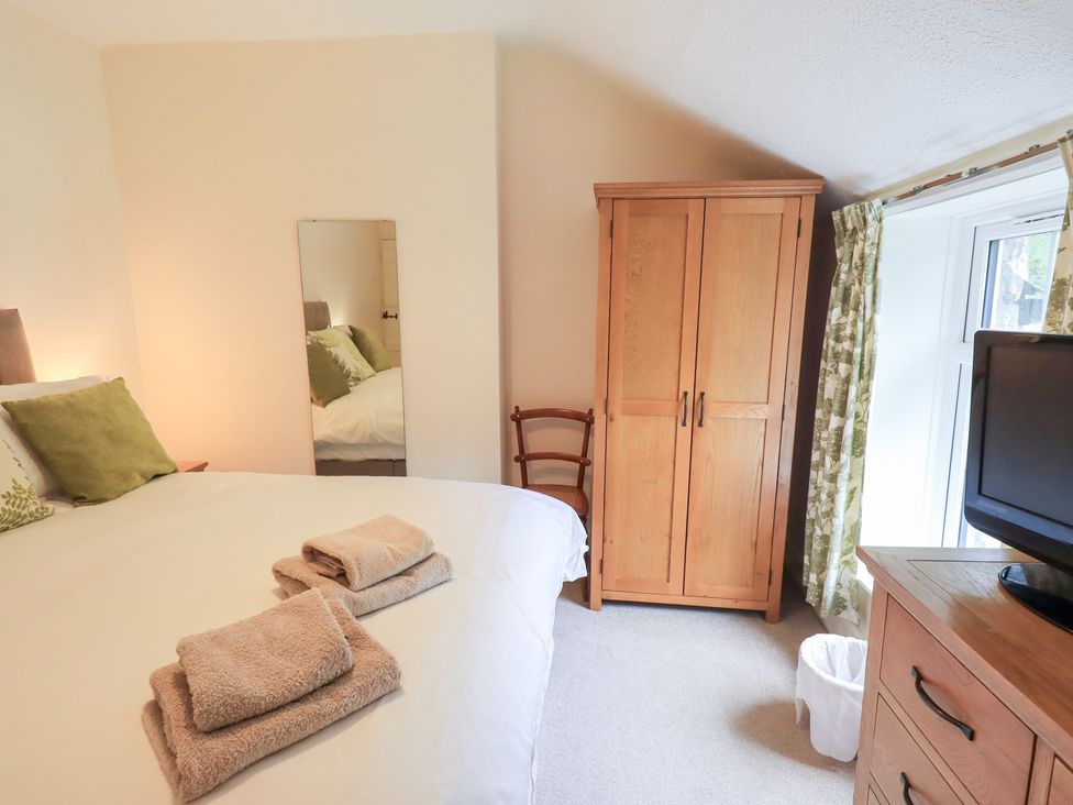 A bedroom with a bed and wardrobe at Millcroft in Glenridding