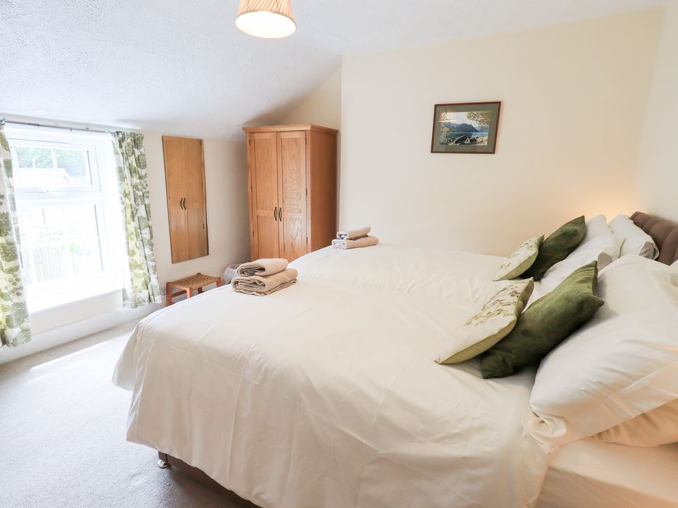 A bedroom with two beds and a dresser at Millcroft in Glenridding
