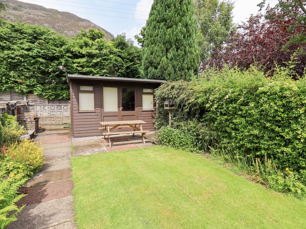 A garden with a shed and picnic table at Millcroft, Glenridding