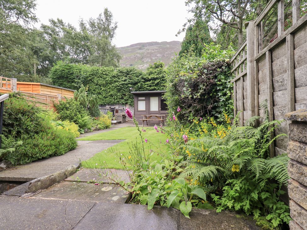 A garden with a seating area and plants at Millcroft in Glenridding