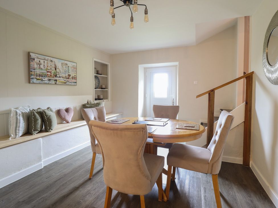 A dining room with a round table and chairs at Cefn Uchaf Cottage in Llanbedr