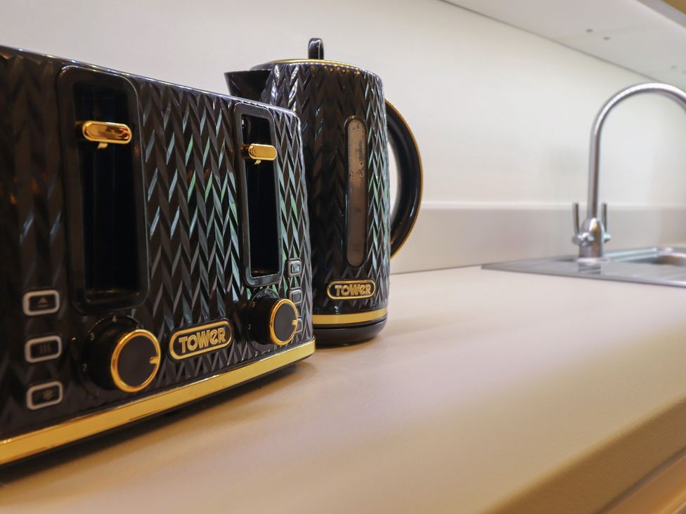 A kitchen with a toaster and kettle on the countertop at Cefn Uchaf Cottage in Llanbedr