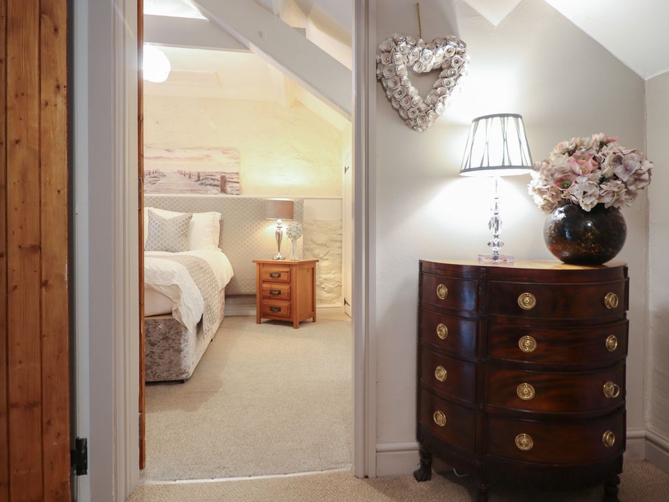 A bedroom with a bed and a bedside table at Cefn Uchaf Cottage in Llanbedr