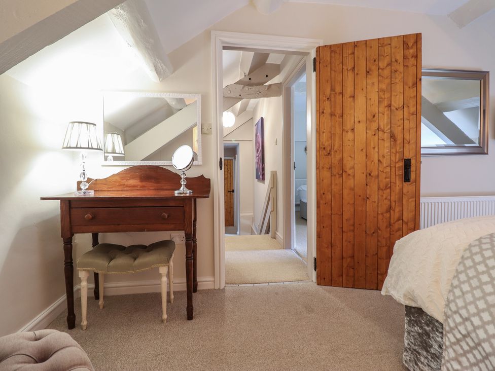 A bedroom with a vanity table and mirror at Cefn Uchaf Cottage Llanbedr