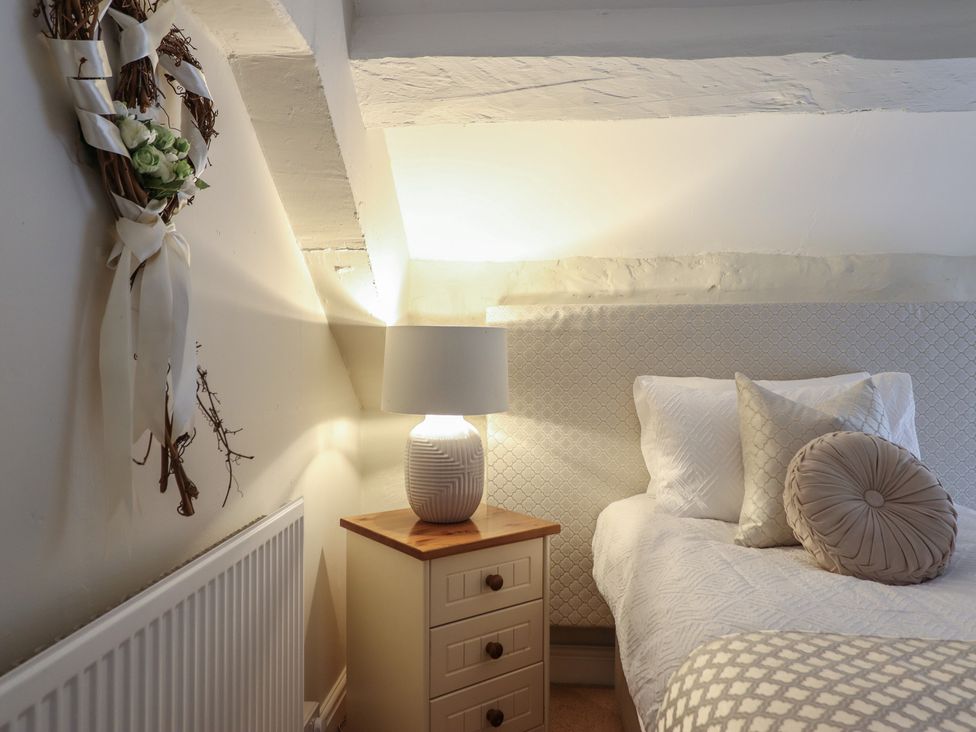 A bedroom with a bed and nightstand at Cefn Uchaf Cottage in Llanbedr