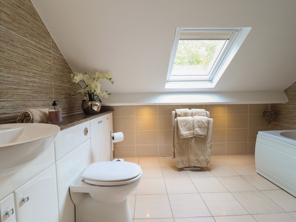 A bathroom with a sink, toilet, and bathtub at Cefn Uchaf Cottage, Llanbedr