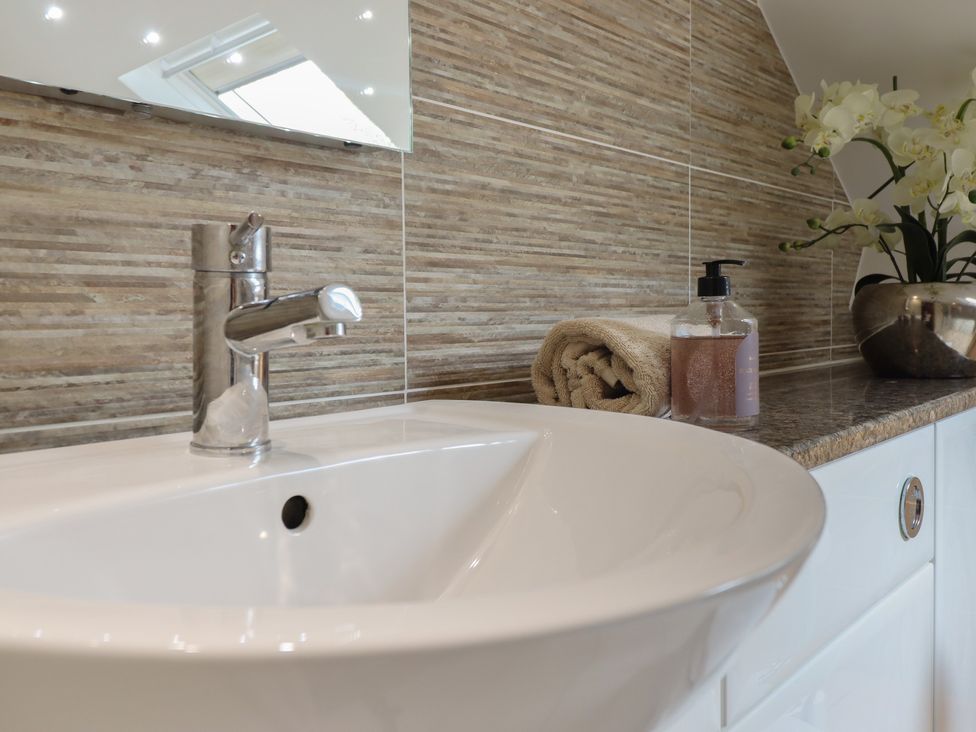 A bathroom sink with a faucet and soap dispenser at Cefn Uchaf Cottage Llanbedr