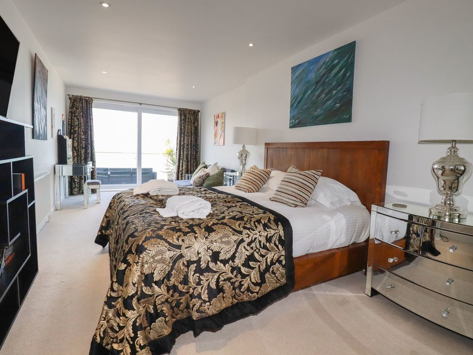A bedroom with a large bed and a nightstand at The View in Newquay