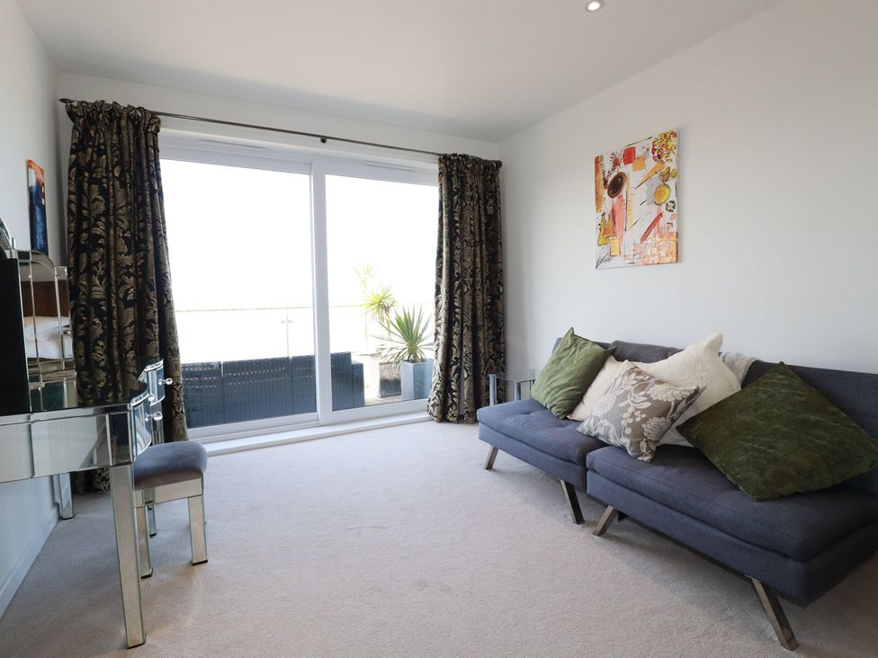 A living room with a sofa and sliding glass door at The View in Newquay
