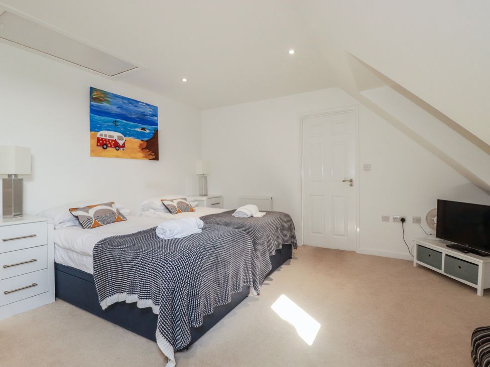 A bedroom with two beds and a television at The View in Newquay