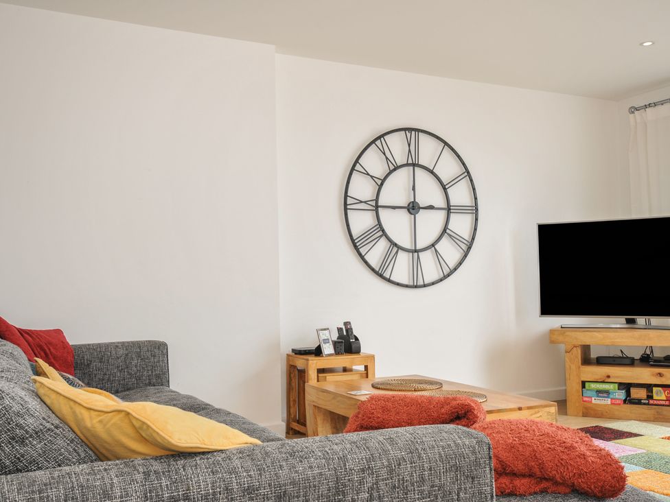 A living room with a clock and a television at The View in Newquay