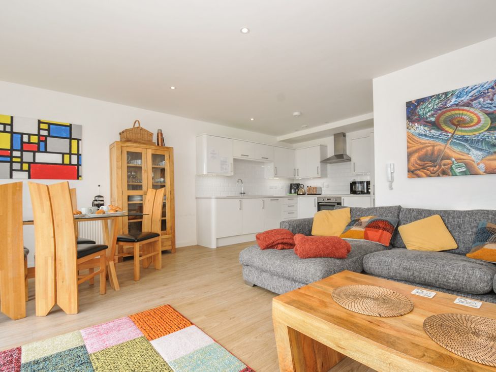 A living room with sofa and dining area at The View in Newquay