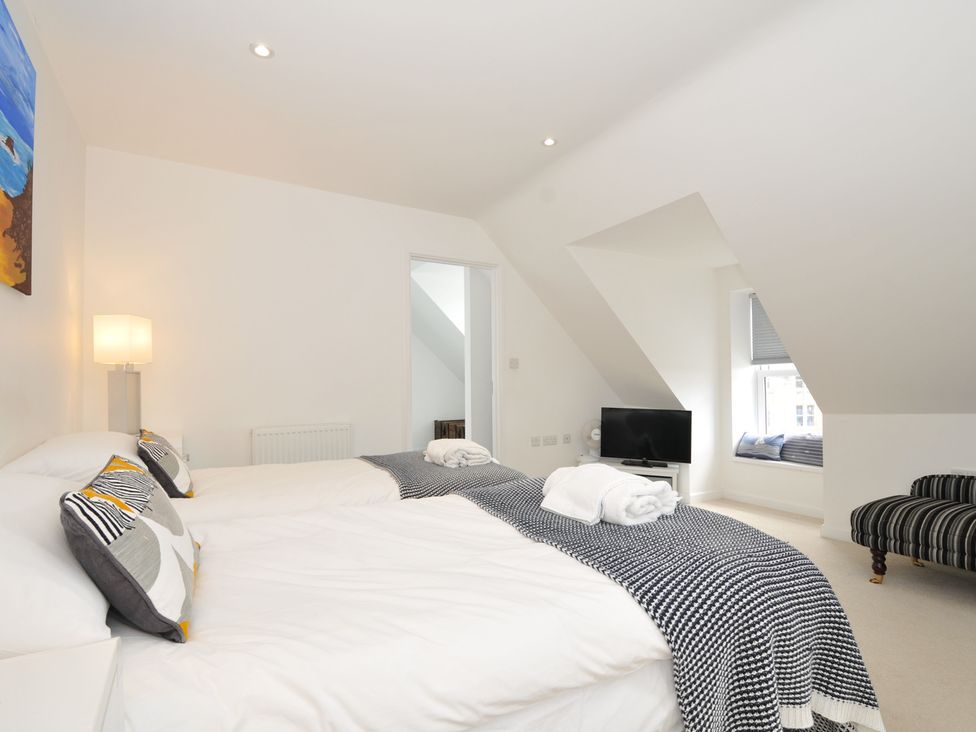 A bedroom with two beds and a television at The View in Newquay