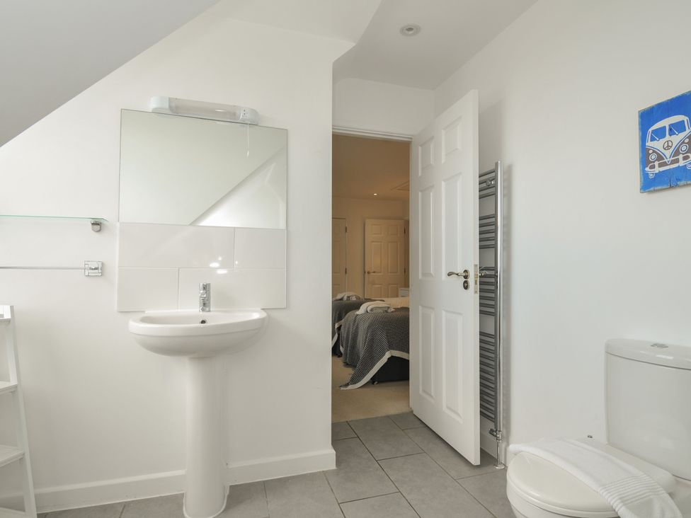 A bathroom with a sink, mirror, and toilet at The View in Newquay