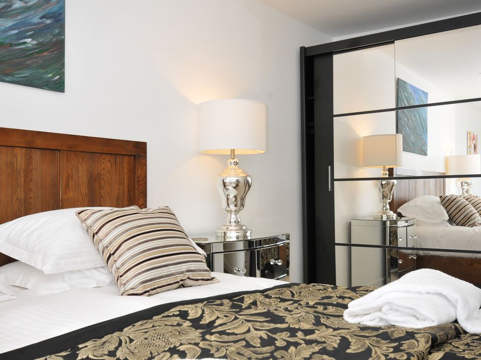 A bedroom with a bed and bedside lamp at The View in Newquay
