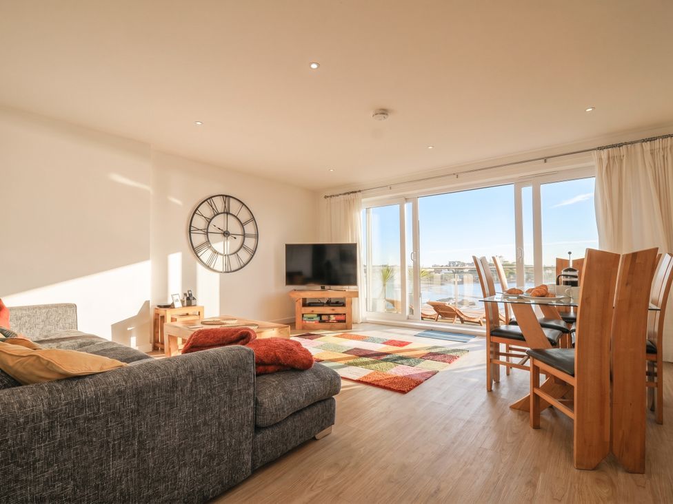 A living room with a sofa and dining area at The View in Newquay