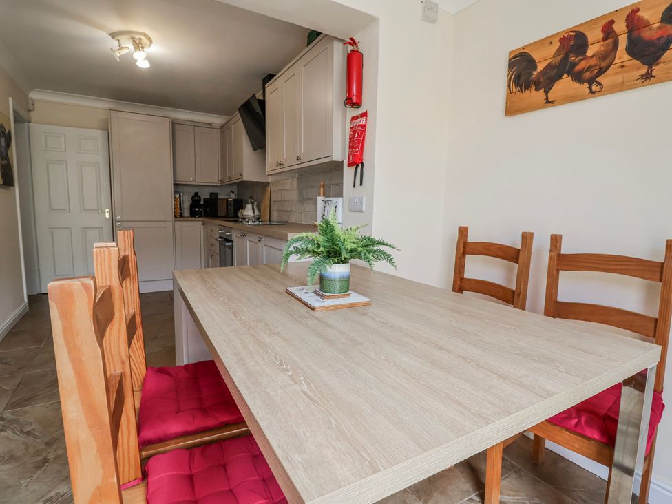 A kitchen with a dining table and chairs at Riverlea in Dyserth