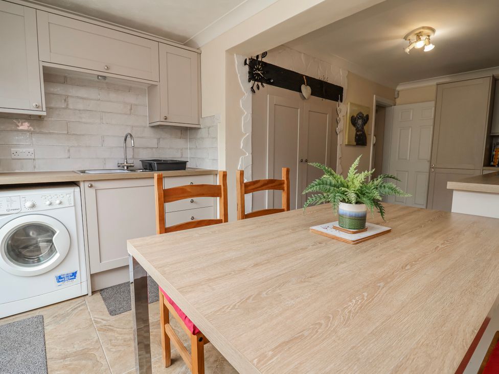 A kitchen with a table and chairs at Riverlea in Dyserth