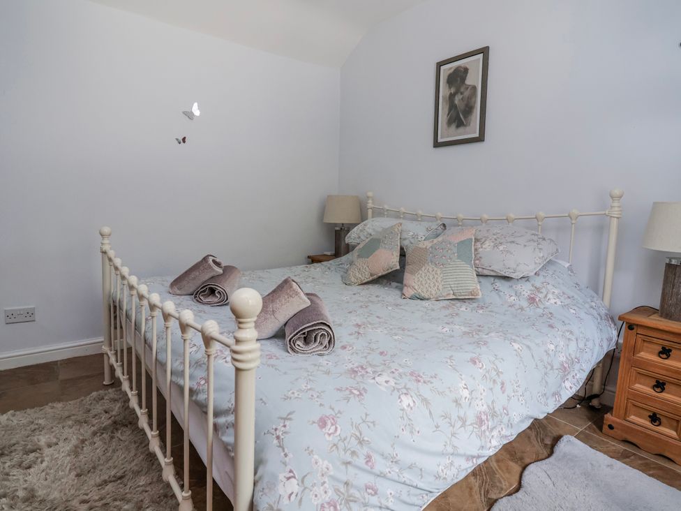 A bedroom with a bed and bedside tables at Riverlea in Dyserth