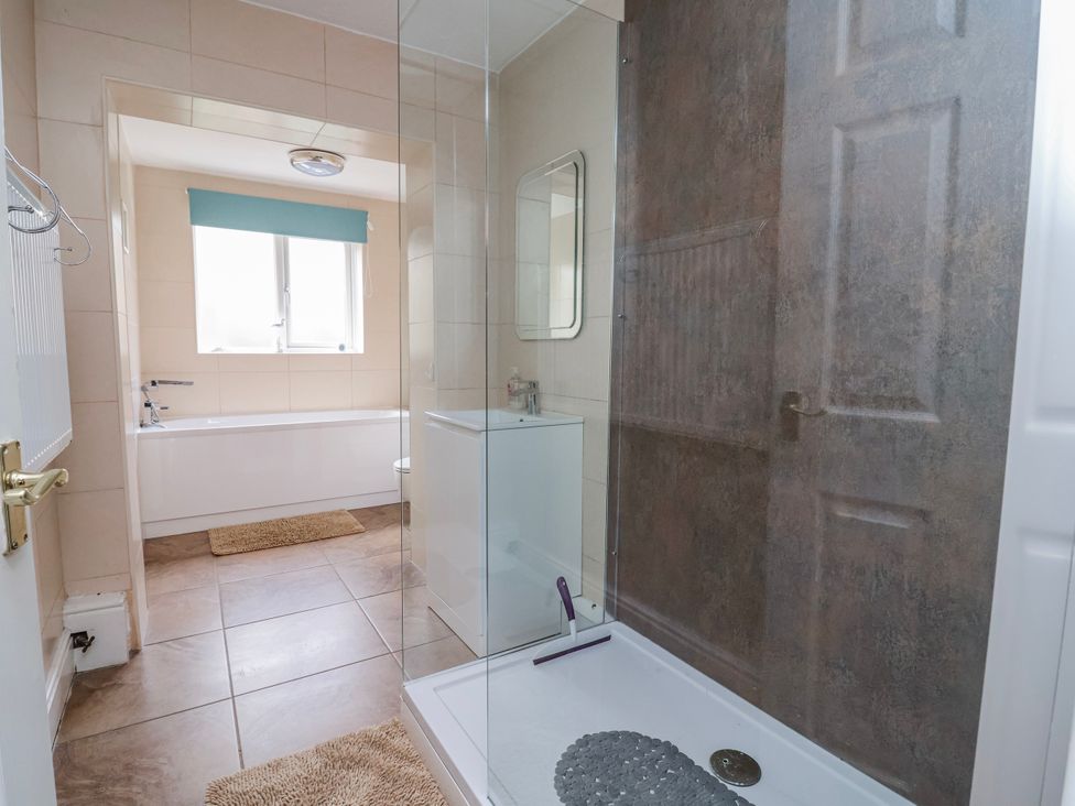 A bathroom with a shower enclosure and bathtub at Riverlea Dyserth