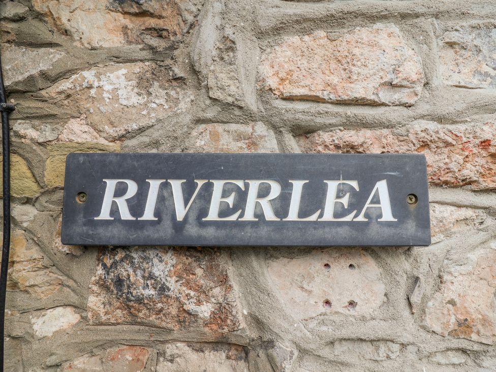 A sign that reads RIVERLEA on a stone wall at Riverlea in Dyserth