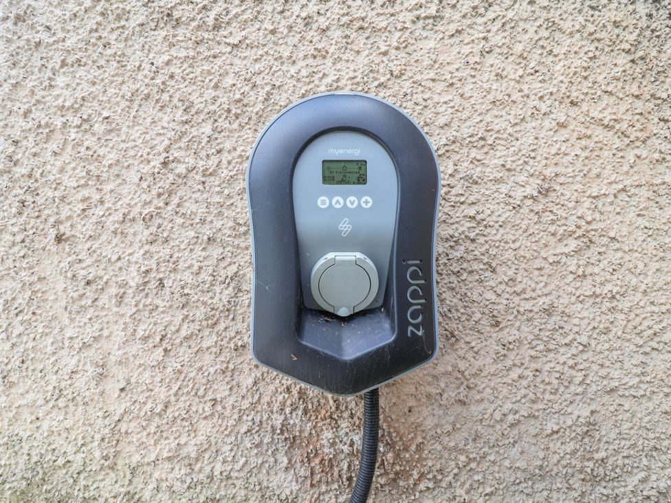 An electric vehicle charger mounted on a wall at Riverlea in Dyserth
