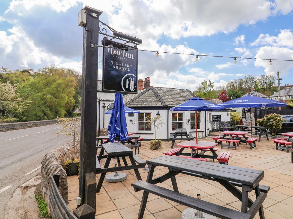 An outdoor seating area with tables and umbrellas at the Flow Inn in Dyserth
