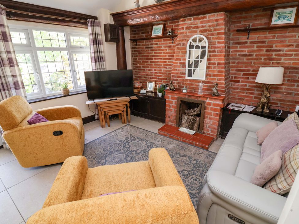 A living room with a tv and fireplace at Ty Cerrig in Dyserth