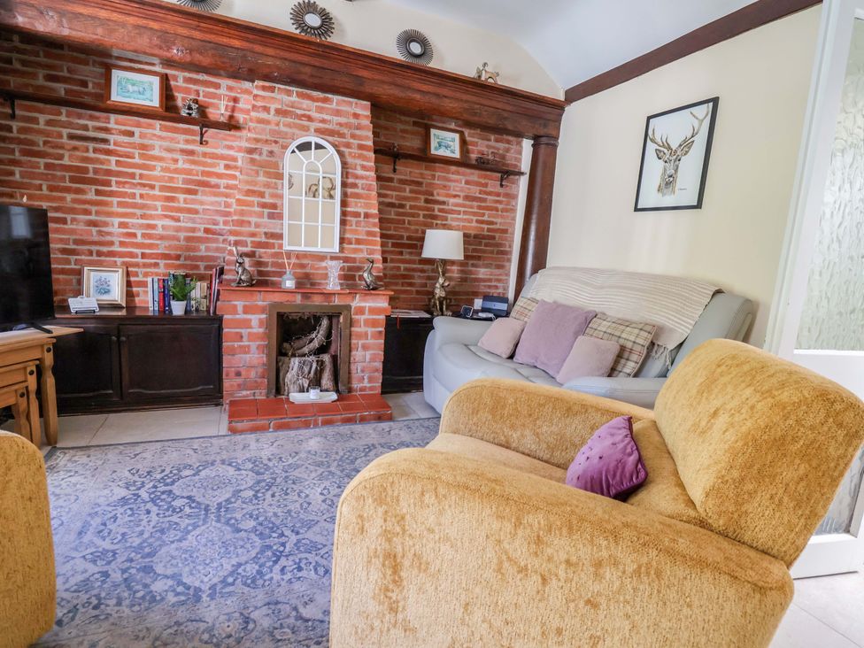 A living room with a sofa and armchair at Ty Cerrig in Dyserth