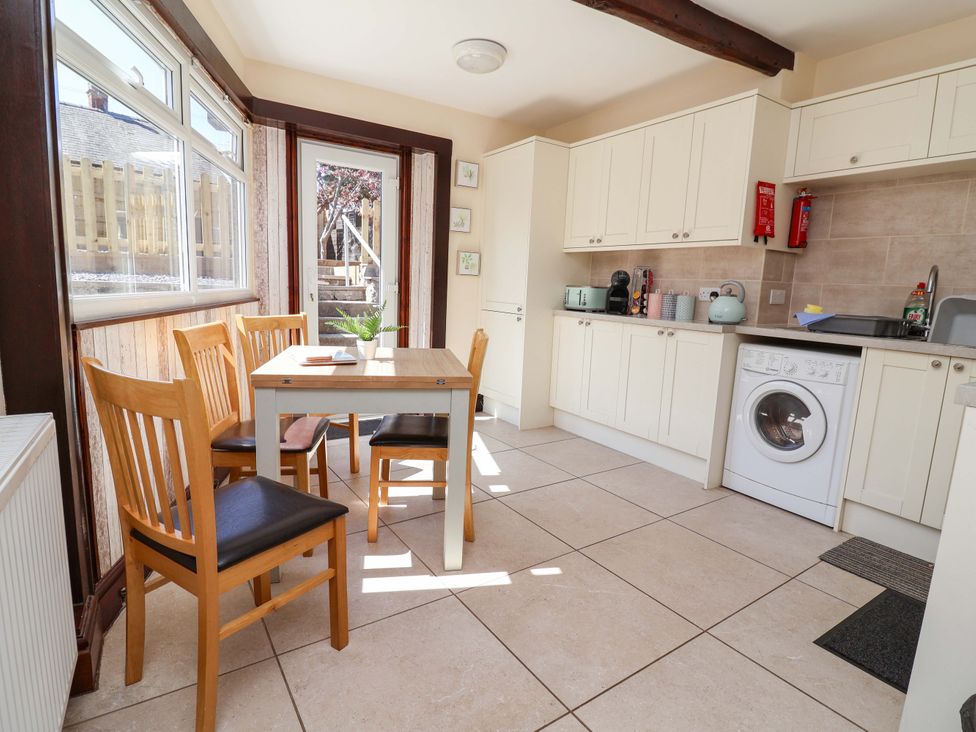 A kitchen with a table and chairs at Ty Cerrig in Dyserth
