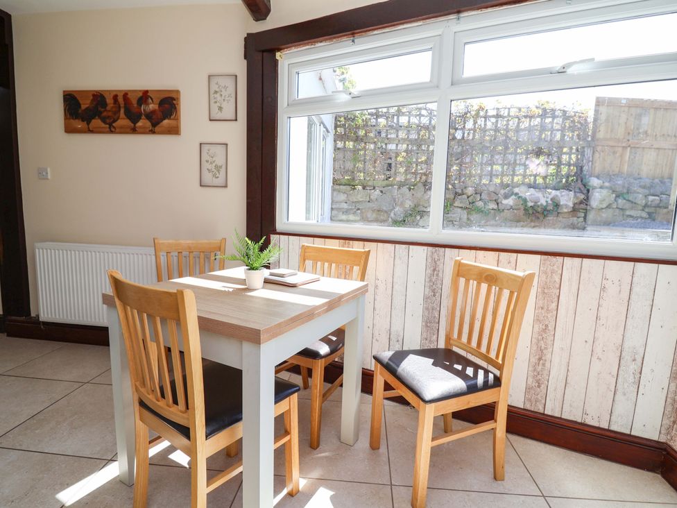 A dining room with a table and chairs at Ty Cerrig in Dyserth