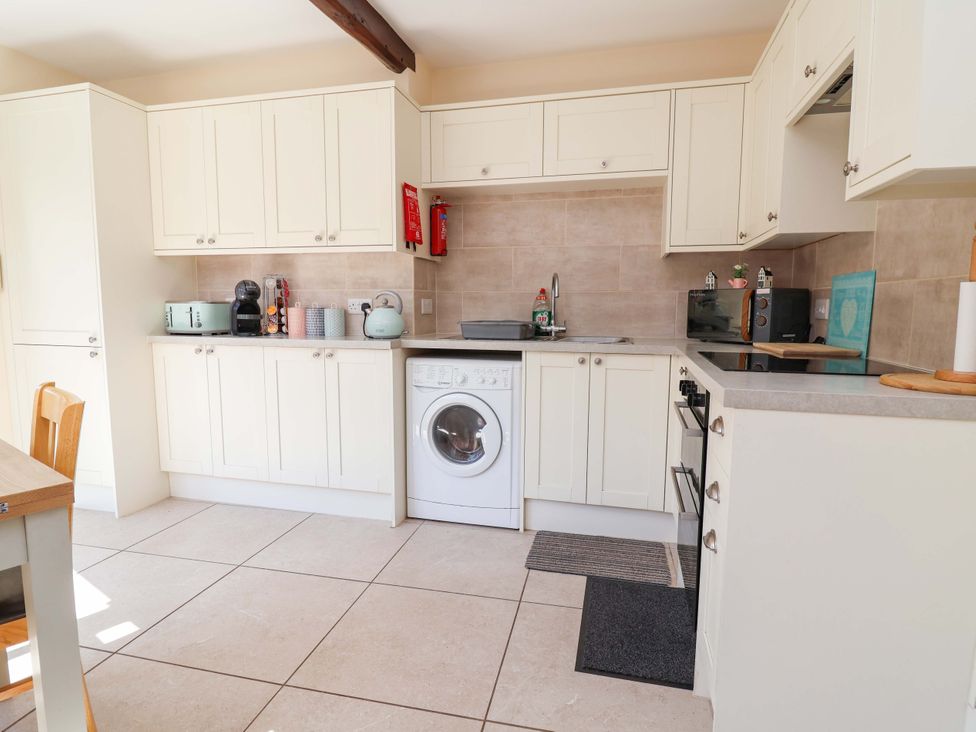 A kitchen with cabinets and appliances at Ty Cerrig Dyserth