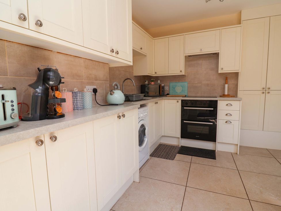 A kitchen with appliances and cabinets at Ty Cerrig in Dyserth