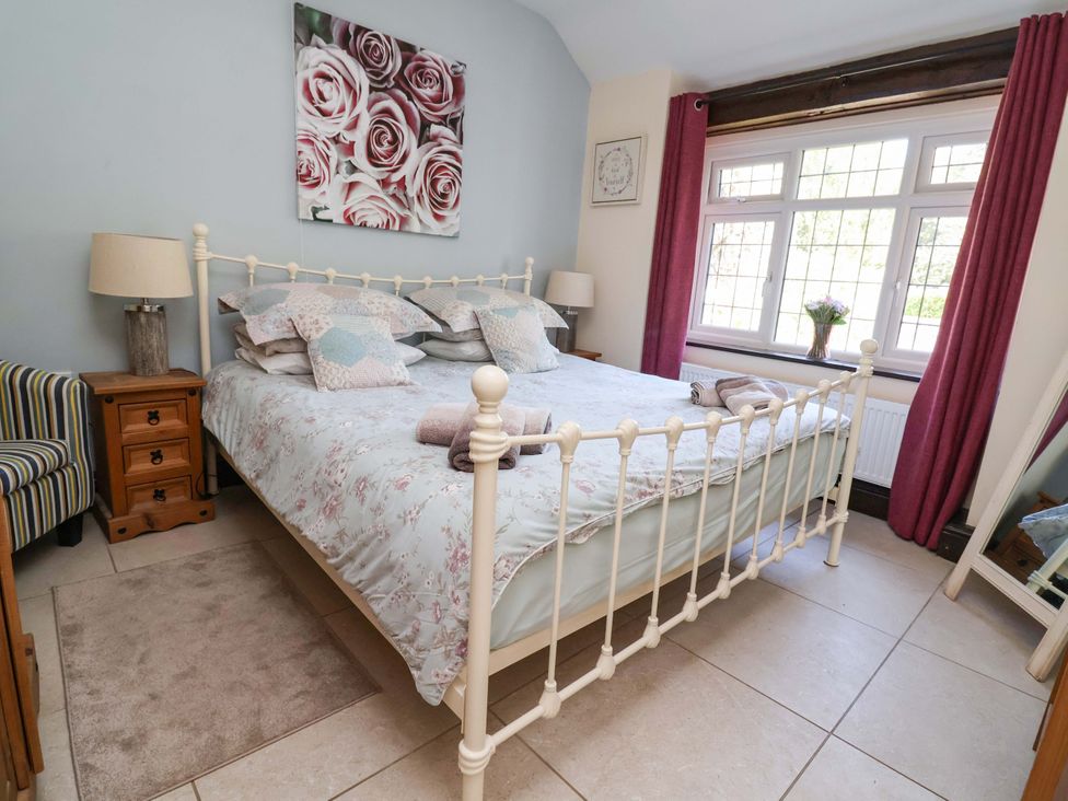 A bedroom with a bed and window at Ty Cerrig in Dyserth