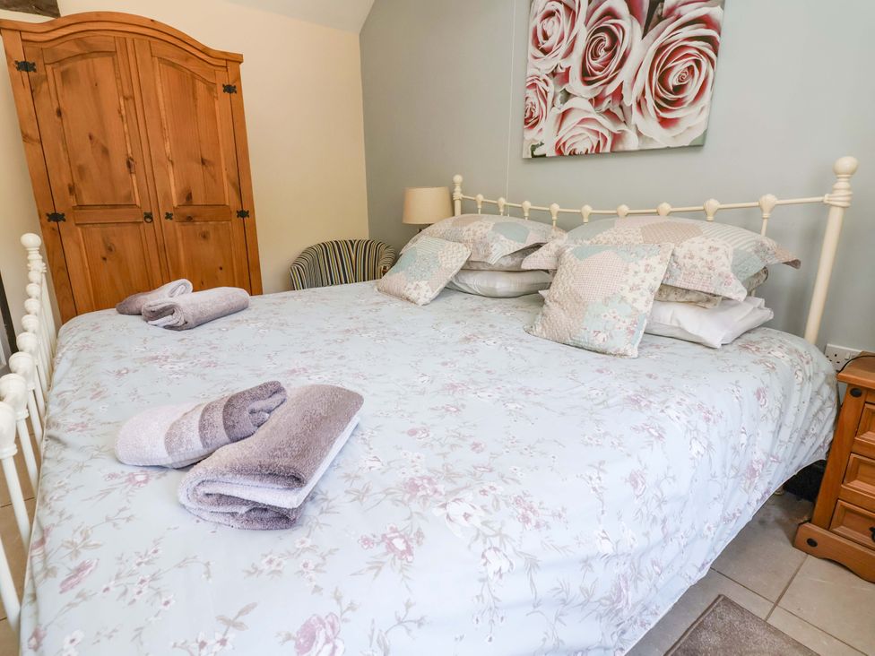 A bedroom with a bed and wardrobe at Ty Cerrig in Dyserth