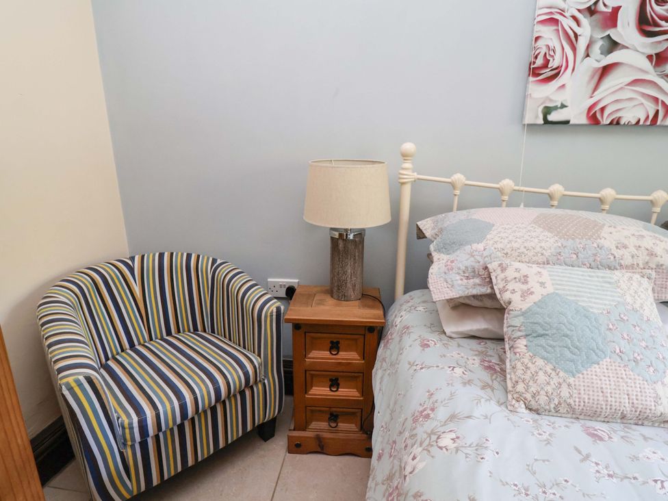 A bedroom with a bed and bedside table at Ty Cerrig in Dyserth