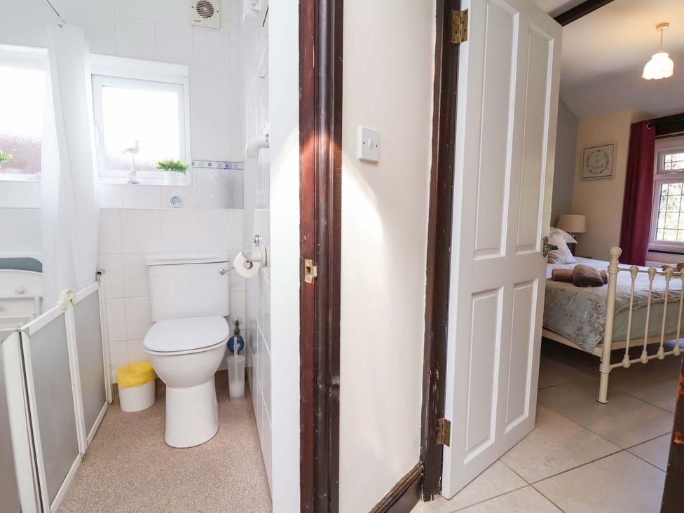 A bathroom with a toilet and a window at Ty Cerrig in Dyserth