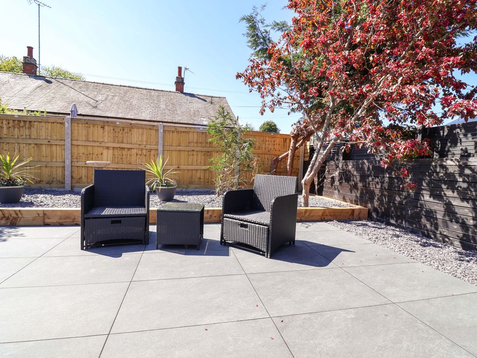 A garden with outdoor seating and plants at Ty Cerrig in Dyserth