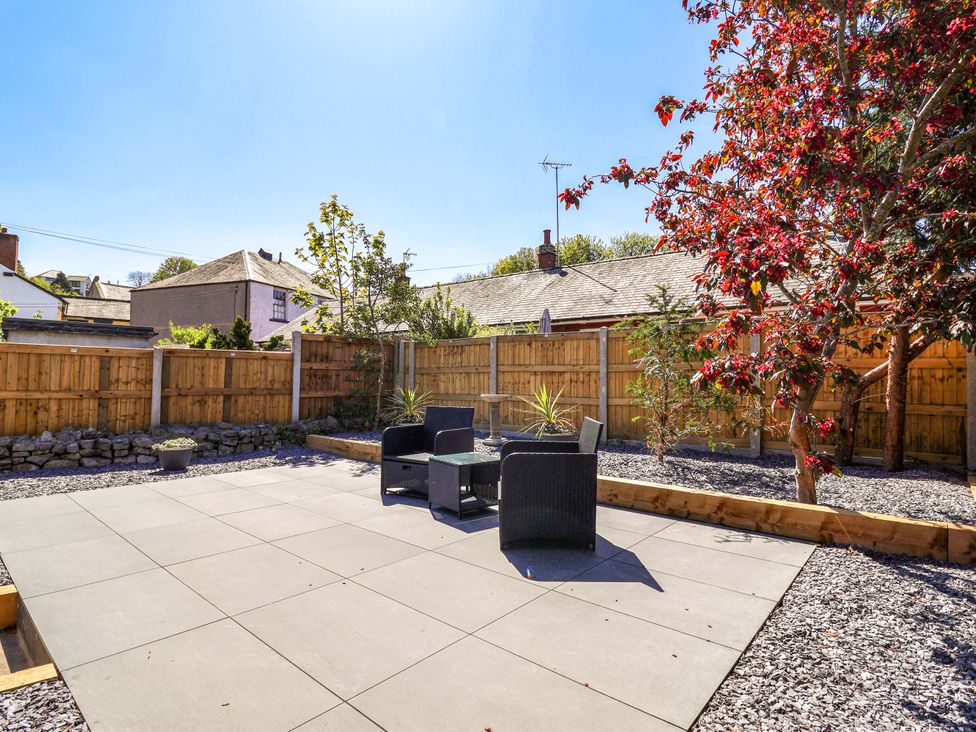 A garden with patio area and chairs at Ty Cerrig Dyserth
