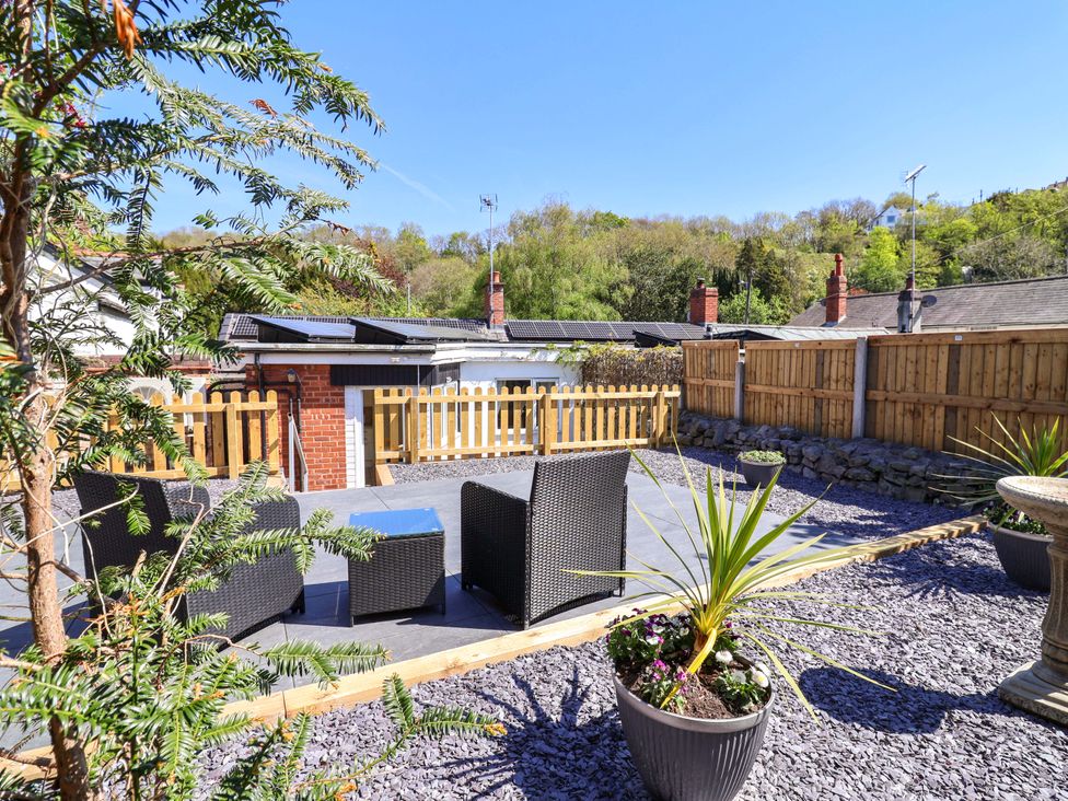 A garden with lounge chairs and a coffee table at Ty Cerrig in Dyserth