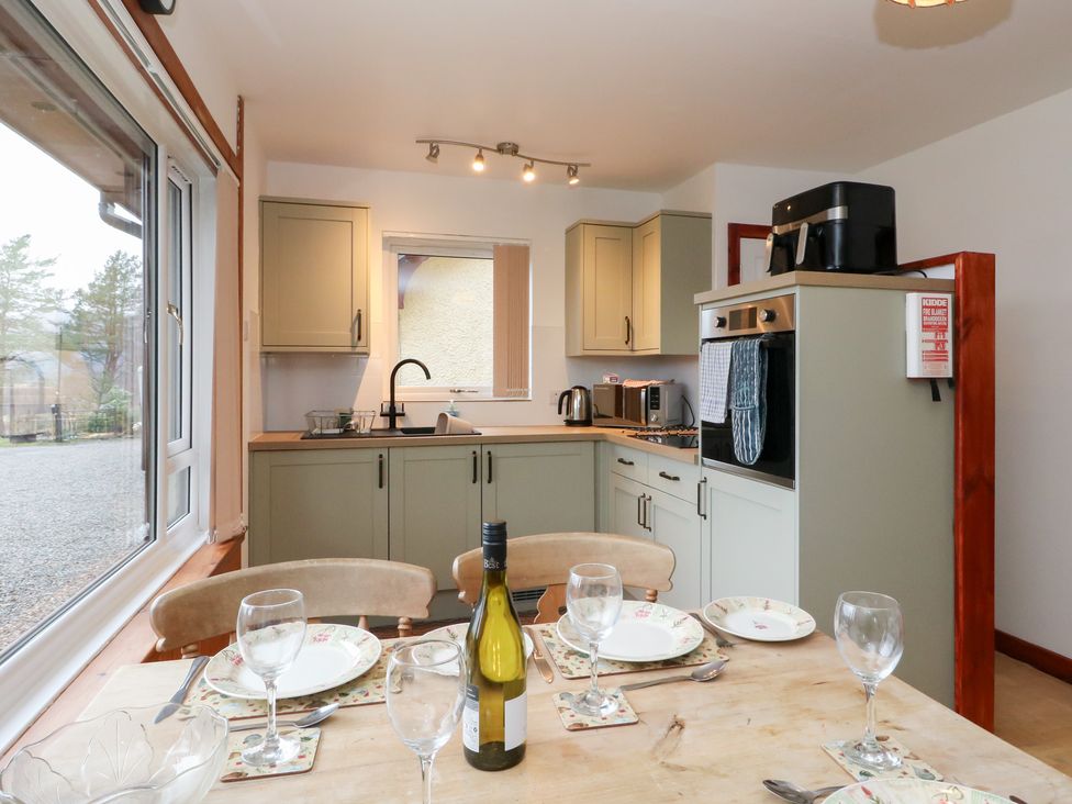 A kitchen with a dining table set at Alba Ben View in Spean Bridge