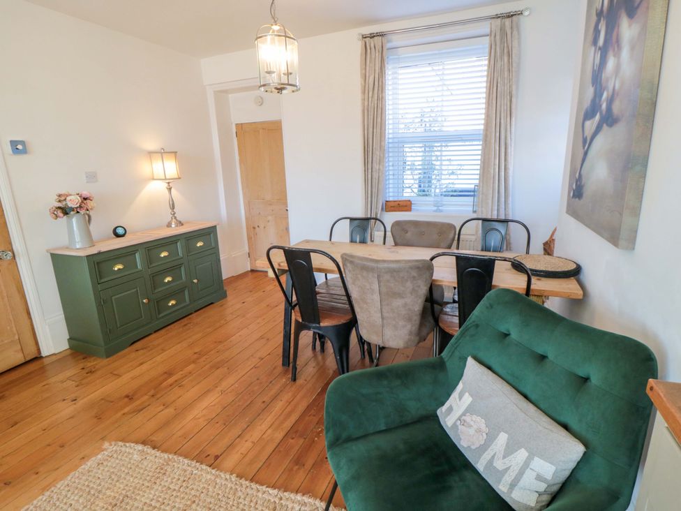 A dining room featuring a table, chairs, and a sofa at Harriet's Cottage in Briggswath