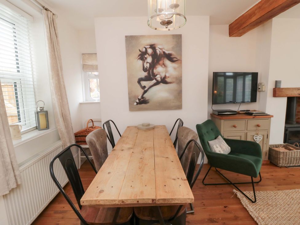 A dining room with a table and chairs at Harriet's Cottage in Briggswath