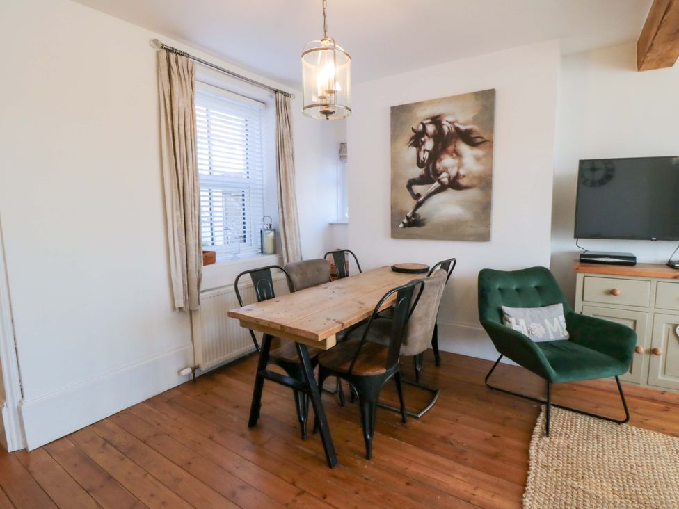 A dining room with a table and chairs at Harriet's Cottage in Briggswath
