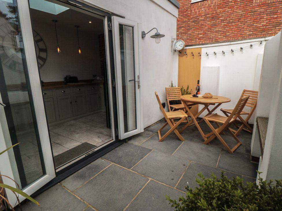 An outdoor patio with a table and chairs at Harriet's Cottage in Briggswath