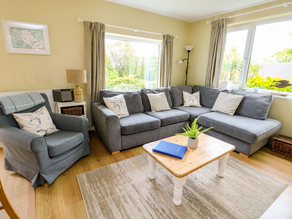 A living room with a sofa, armchair, and coffee table at Sea View in Benllech