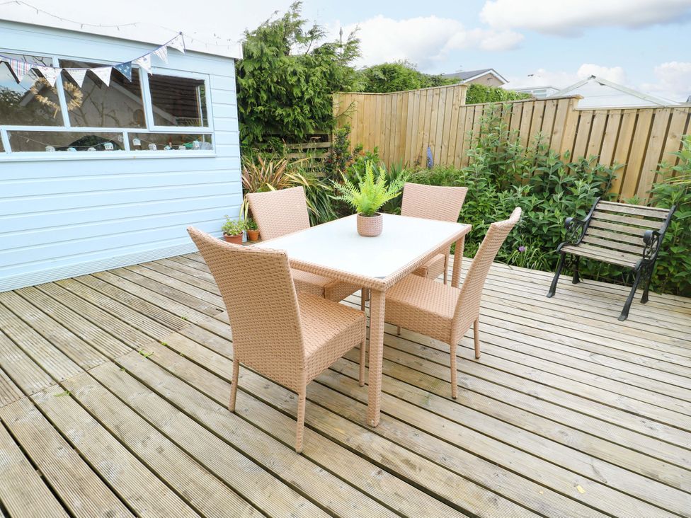 A garden with a table and chairs at Sea View in Benllech